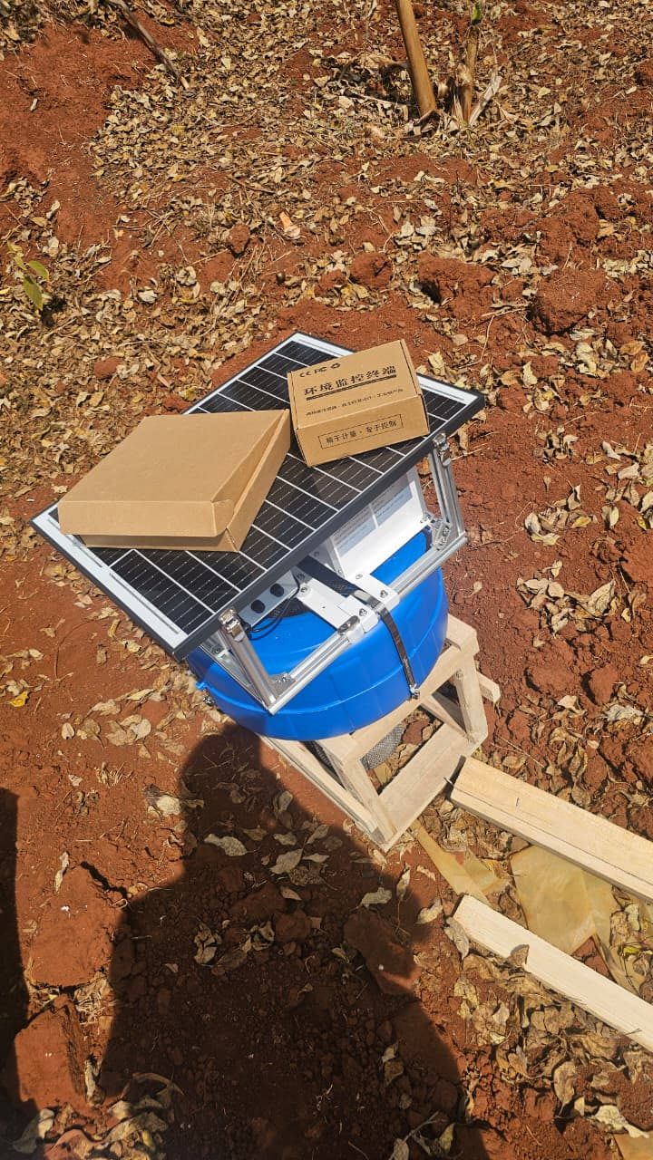 Solar-powered monitoring unit on a wooden stand outdoors