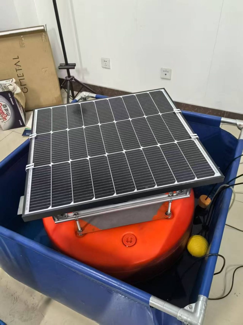 Solar-powered sensor float sitting in a blue tank